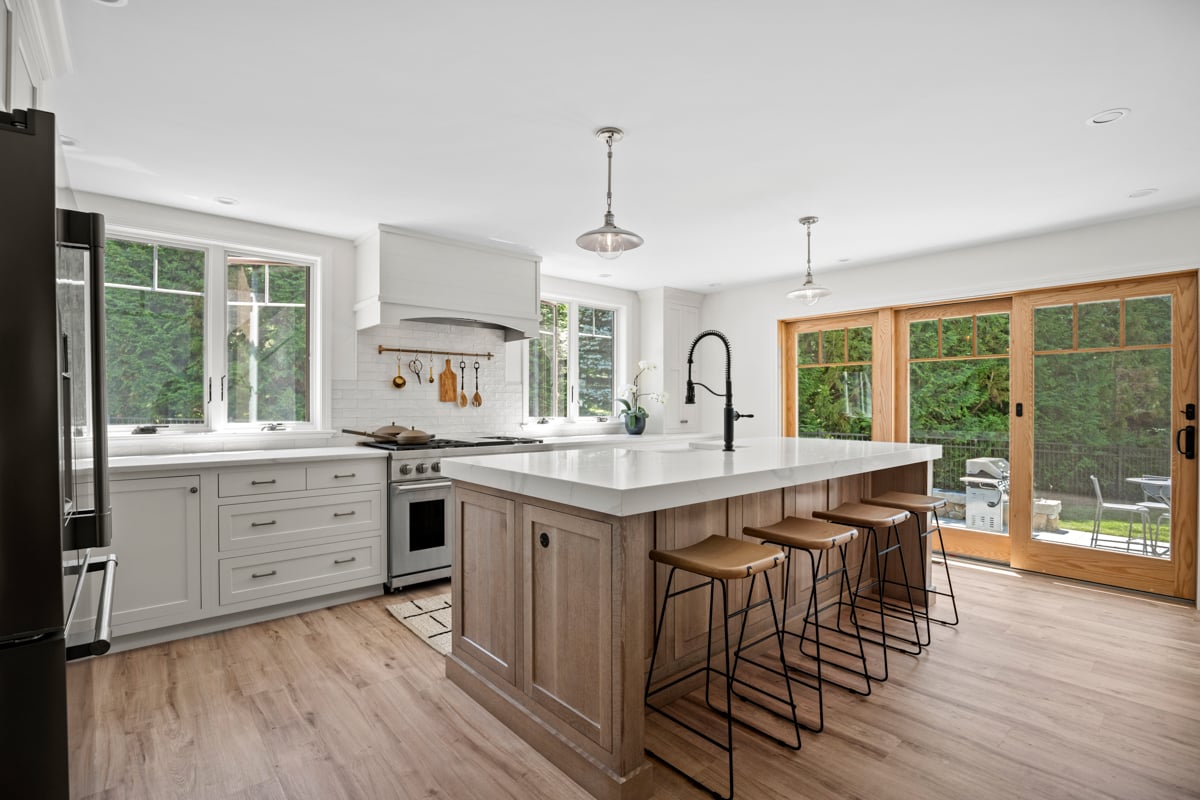 Bright modern kitchen with white cabinets and marble countertops