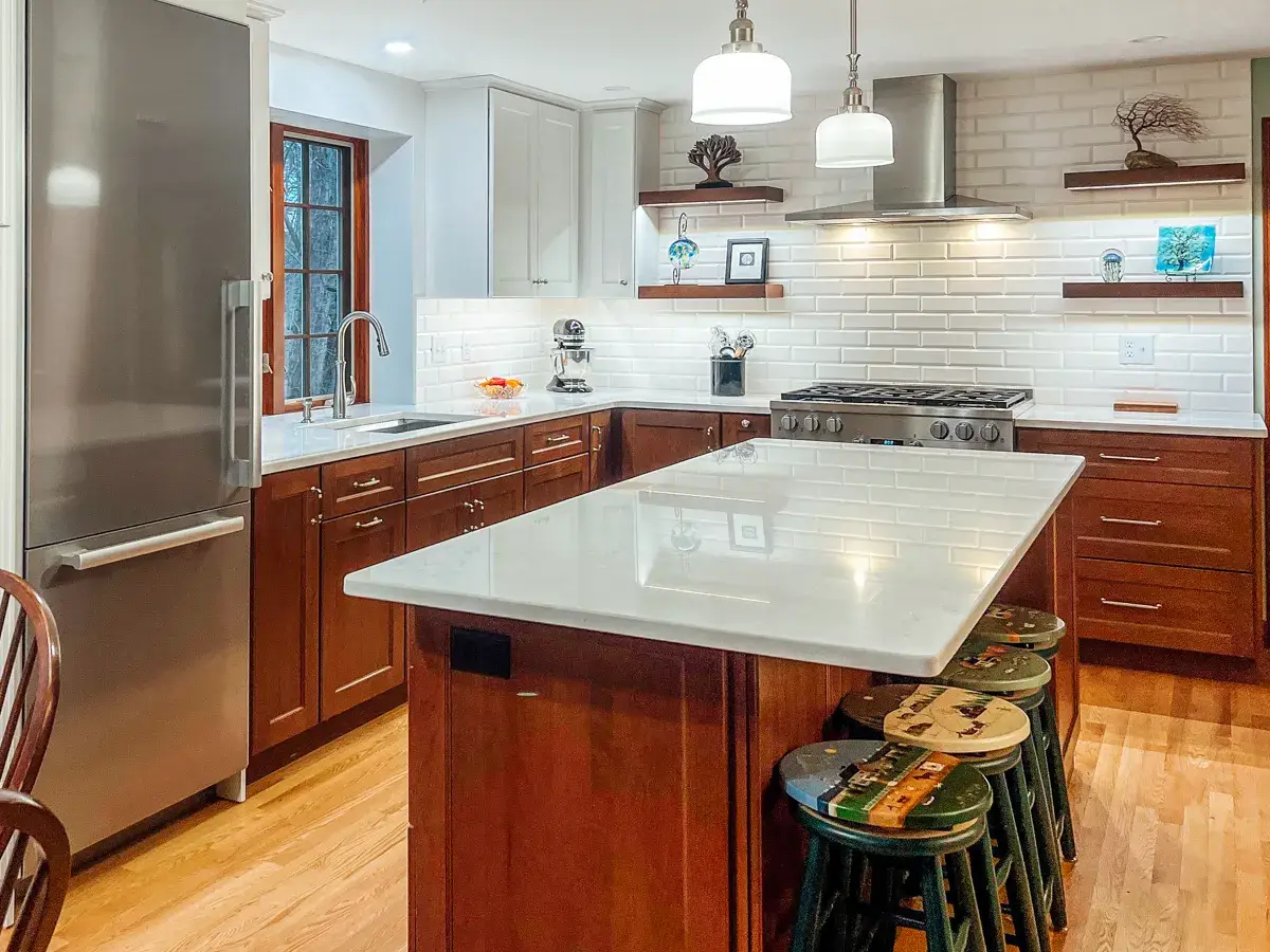 58fba16f-a5fa-4bec-aba4-3c2eeedc342f.webp Stylish kitchen featuring wood cabinets, white quartz countertops, subway tile, and stainless steel appliances.