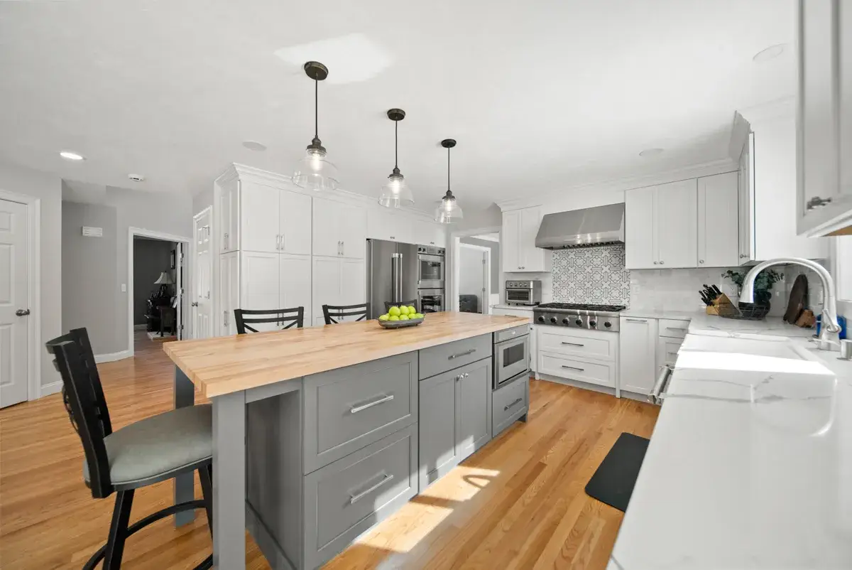 b26c043d-cf28-415b-a71a-b102476ed211.webp Modern kitchen featuring a central island, stainless steel appliances, and hardwood flooring.